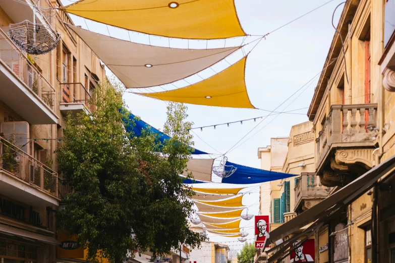 several yellow and white pennants are hanging in a street