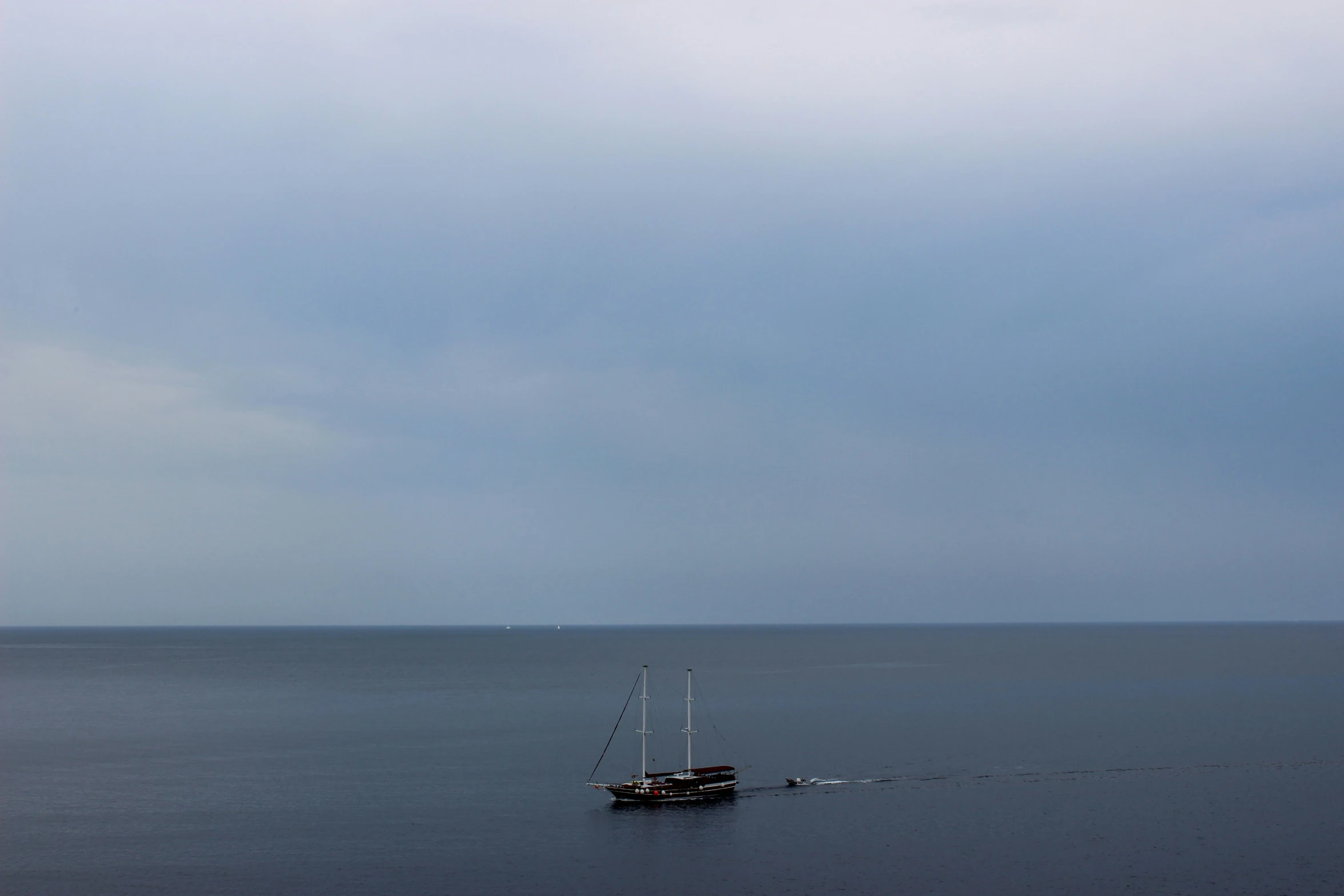 a boat floating on the ocean with sails