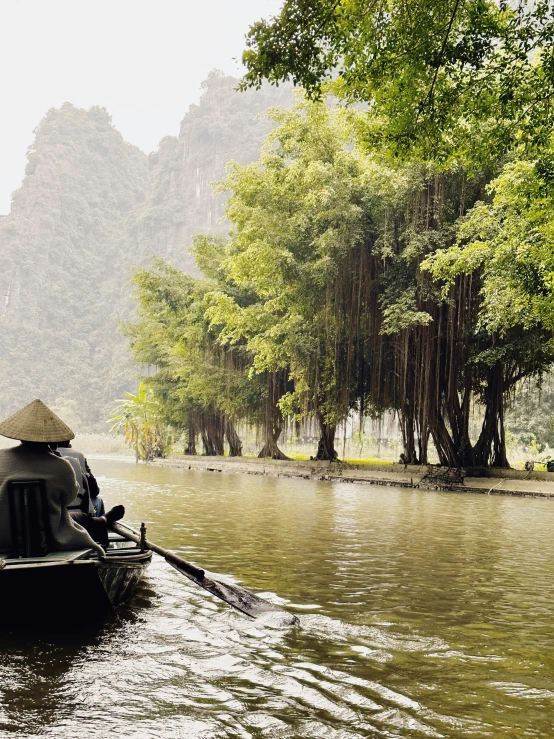 a boat with a hat on is moving down the river