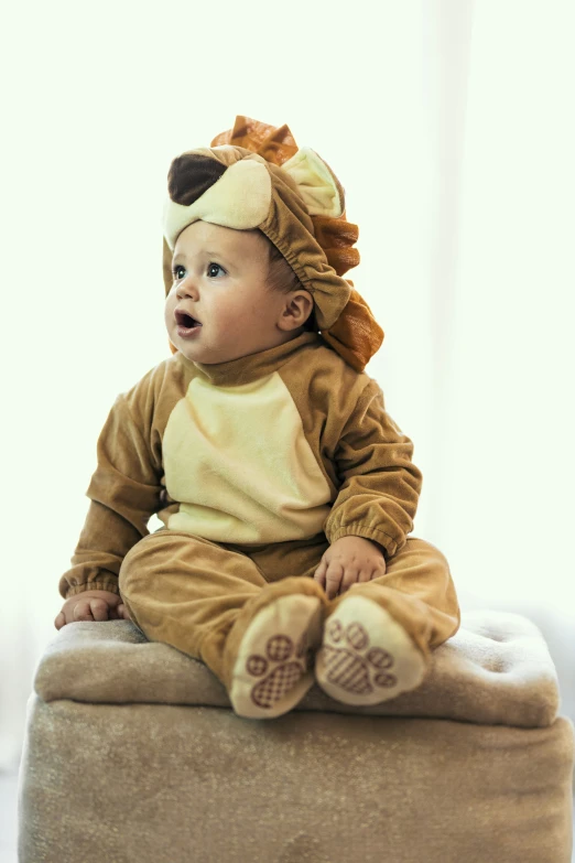 a small child wearing a lion costume sitting on a cushion