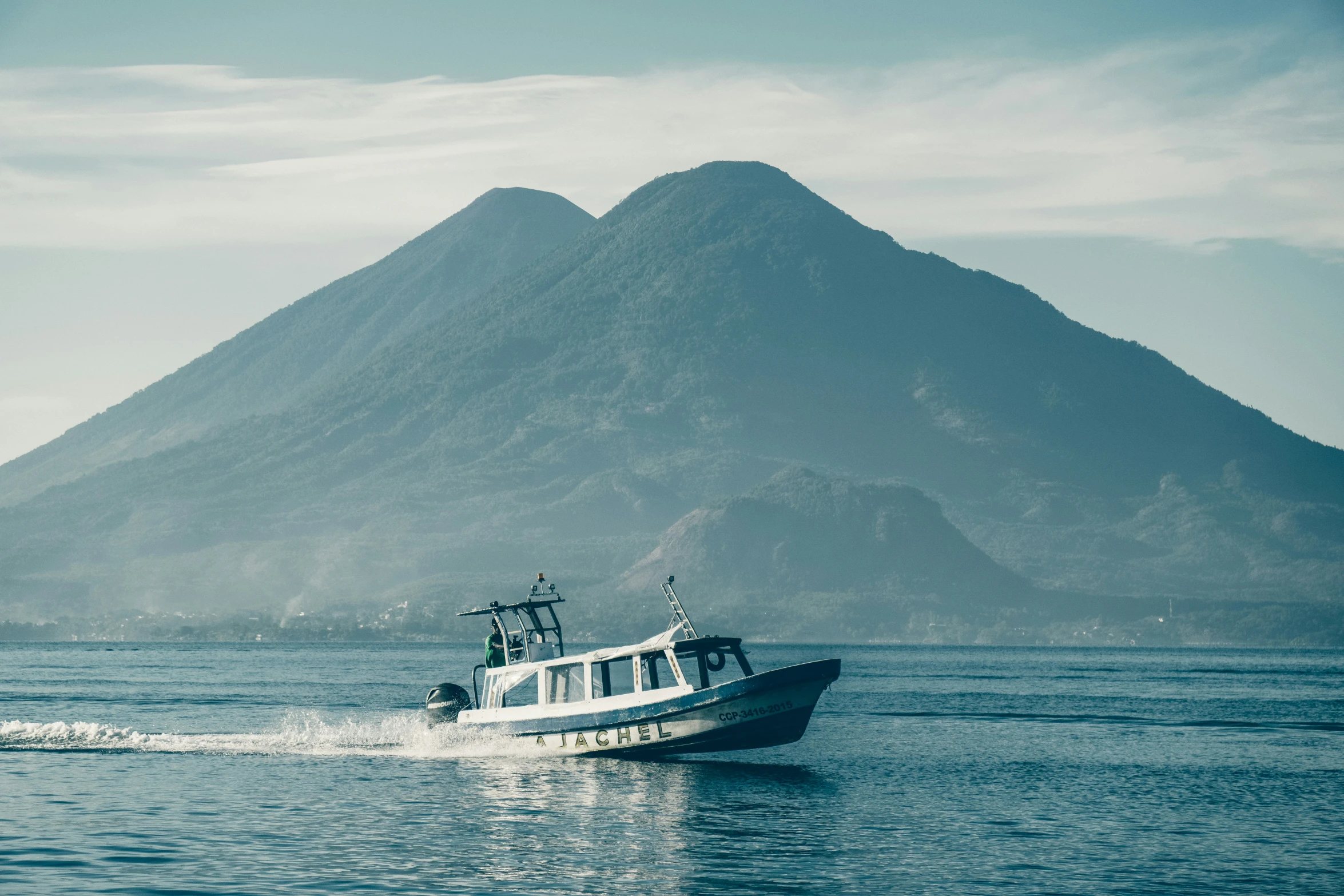 the boat is travelling on the river near mountains