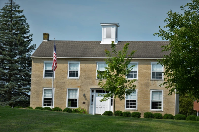 the outside view of a brick building with a american flag at the top