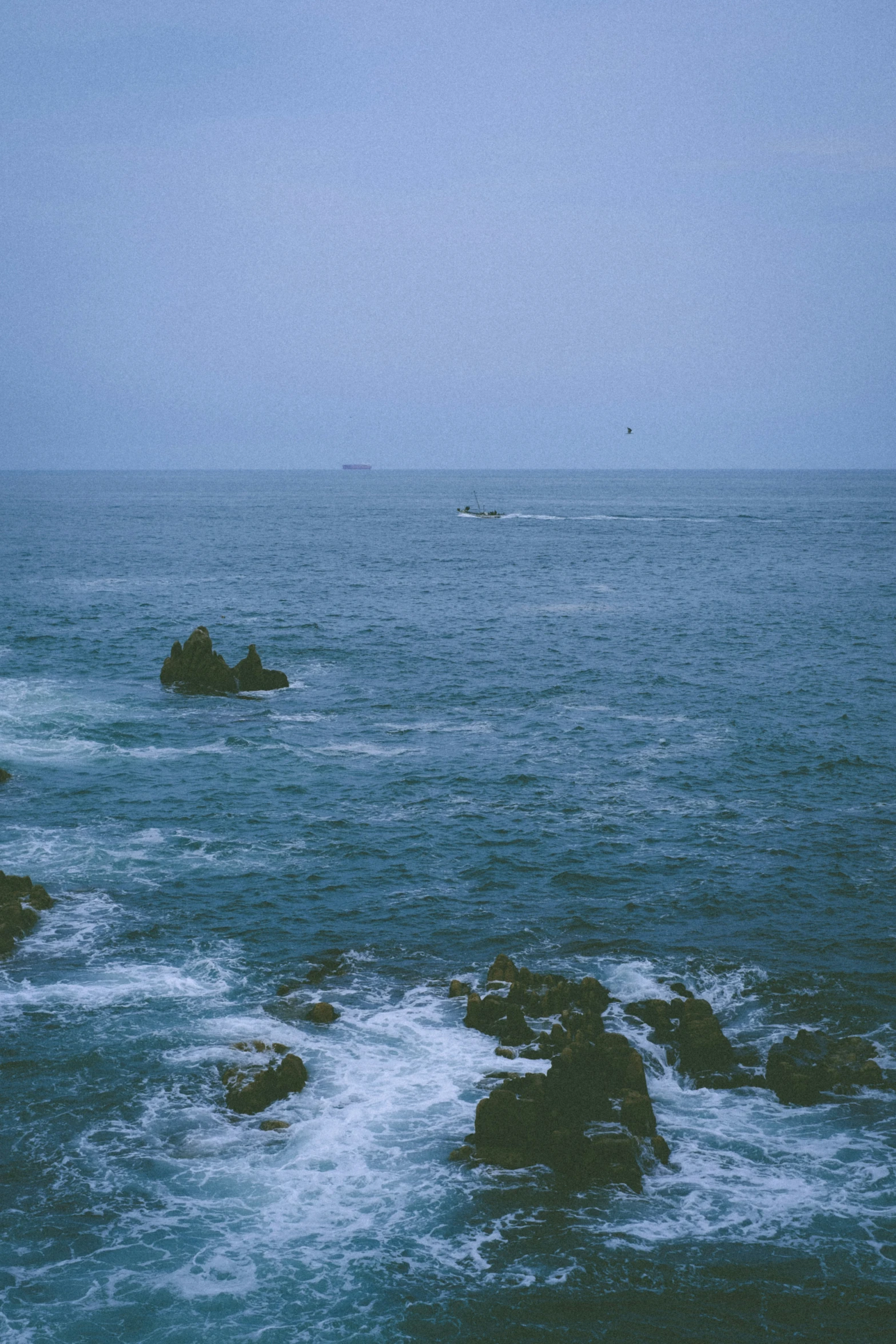 an ocean view looking toward an island with a lighthouse