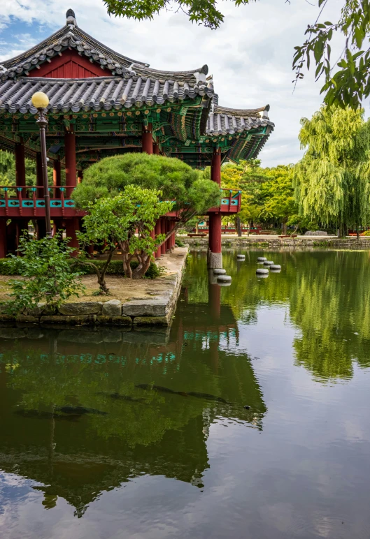 a small pagoda sitting in the middle of a pond