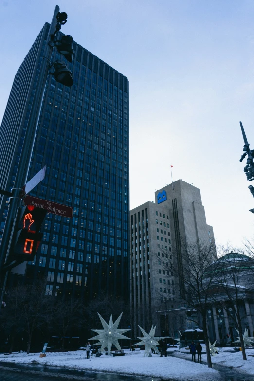 snow covered buildings and a statue in the foreground