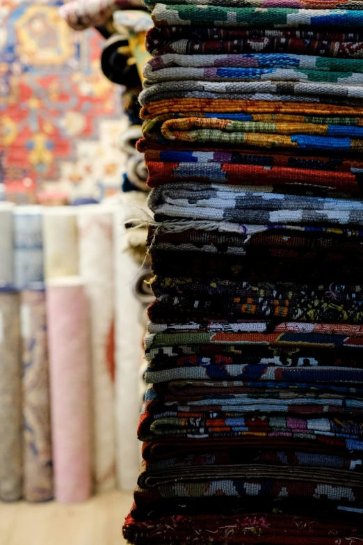 several rows of colorful fabric on display in a store