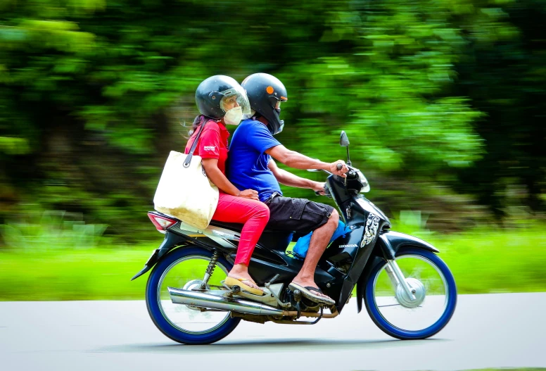 two people riding on the back of a motorcycle