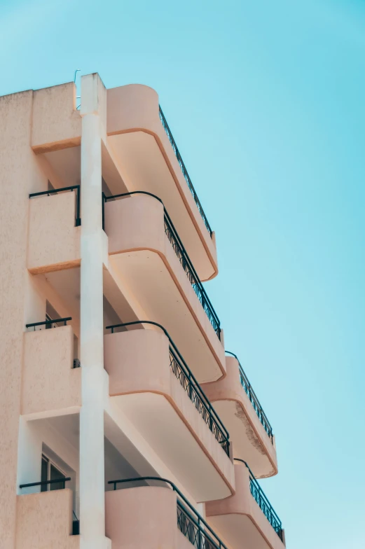 a close - up view of the balconies on a pink building with black wrought - iron balcony railings