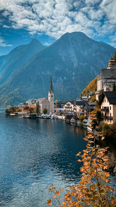 some buildings sitting on a cliff by a large body of water