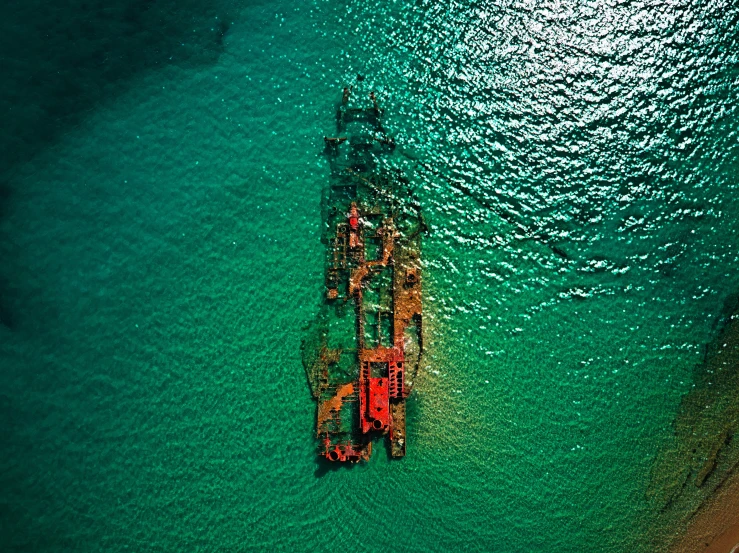 an aerial view of some green water with a barge