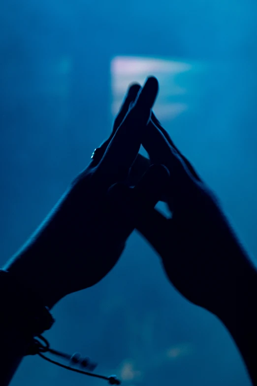 the shadow of someone's hands holding an object in the dark