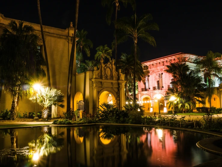 a long exposure picture of a building and pool at night