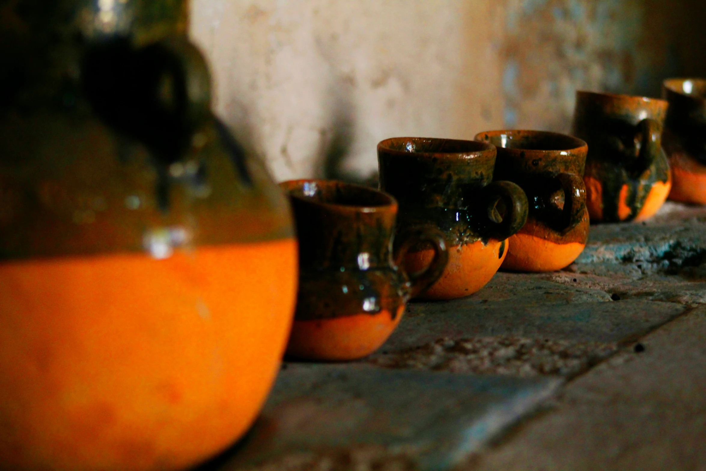 several brown cups sitting next to an orange