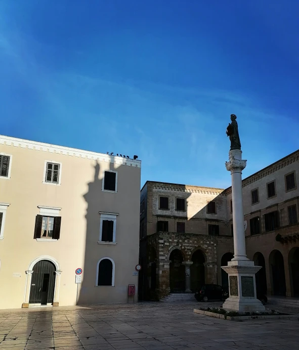 a square with an obelisk and some building that has a clock on it