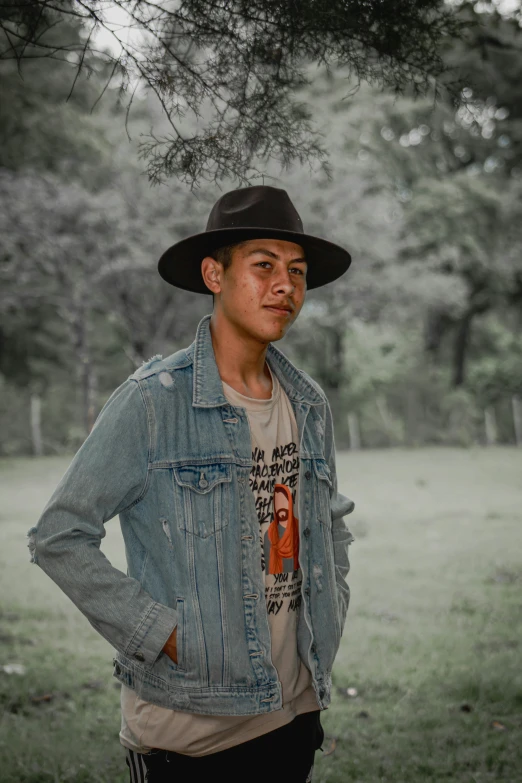 a man with a cowboy hat on standing in a field