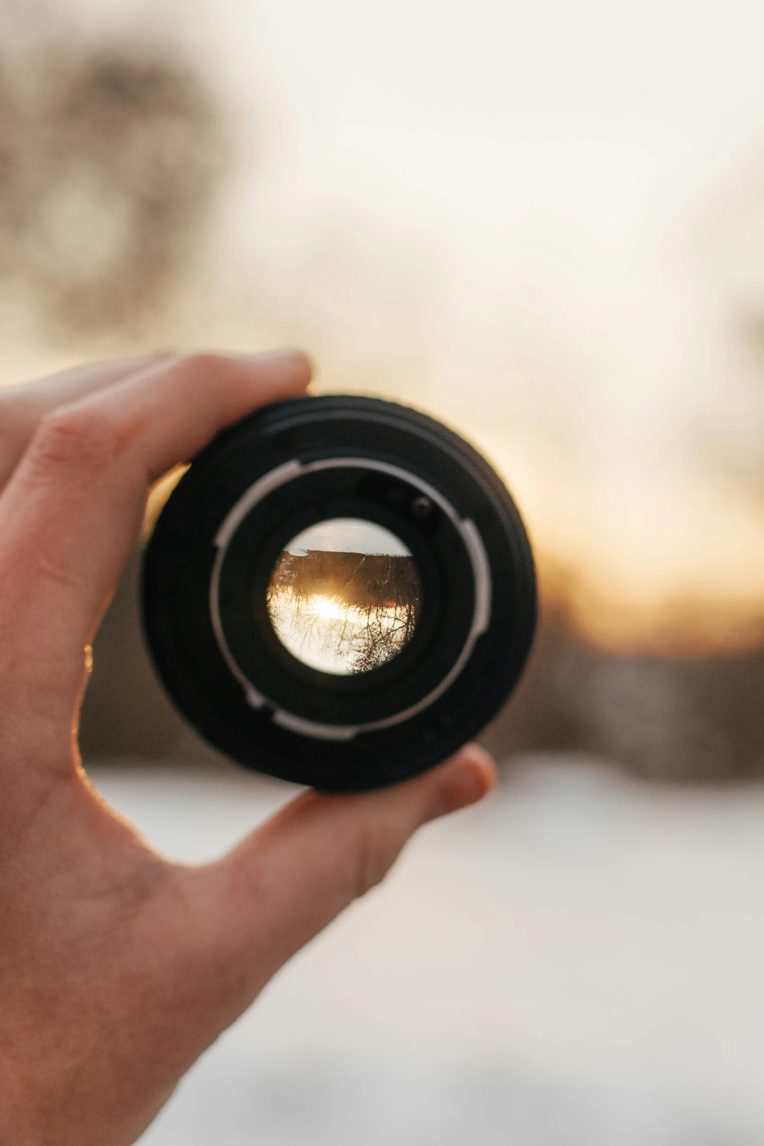 there is a person holding up a small lens