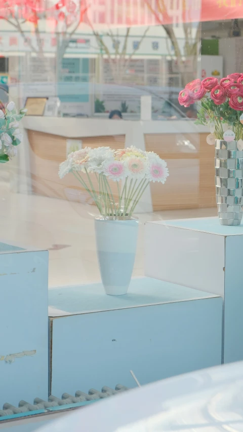 a display with vases and flowers in it