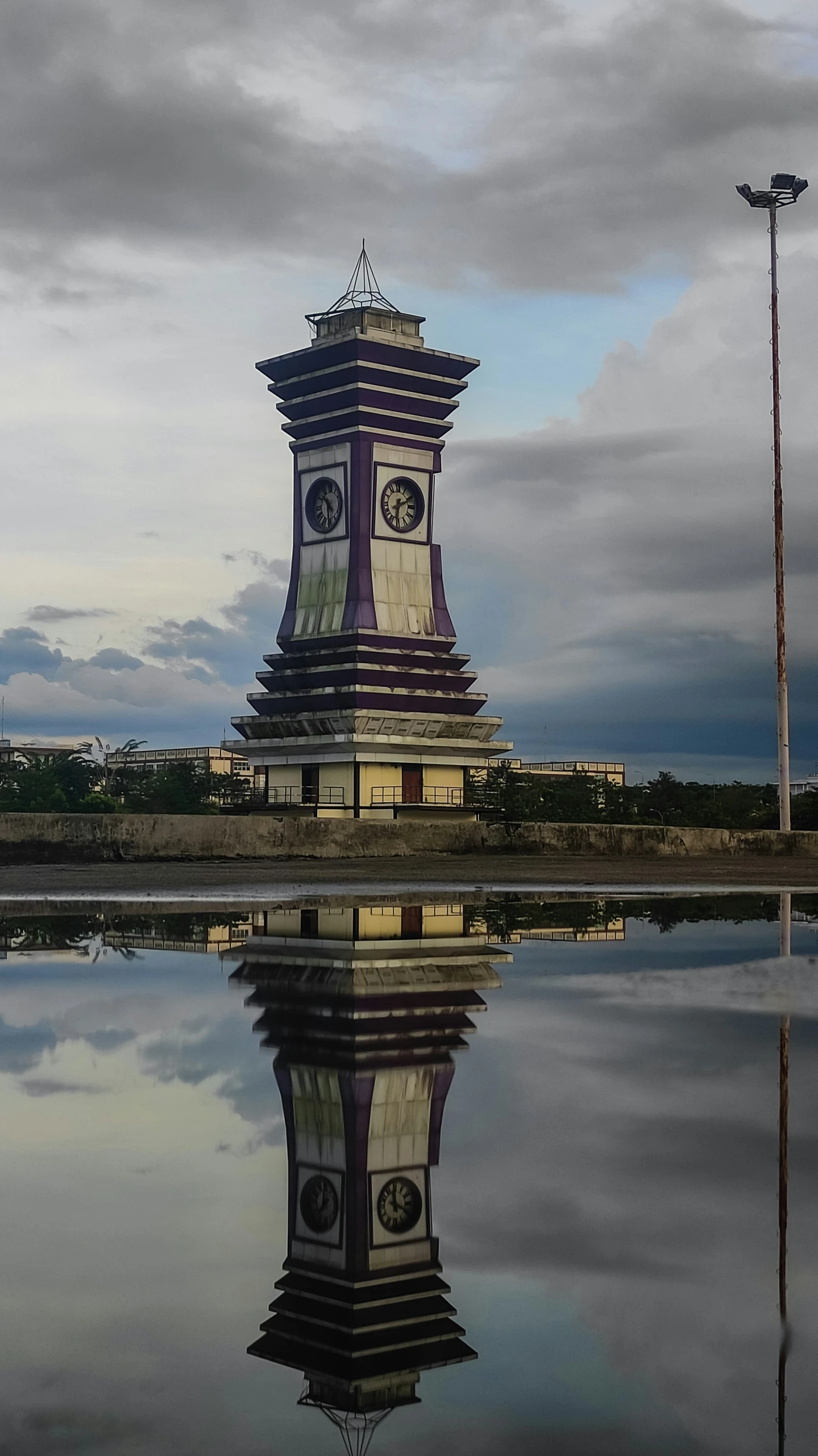 a clock tower with a reflection on the water