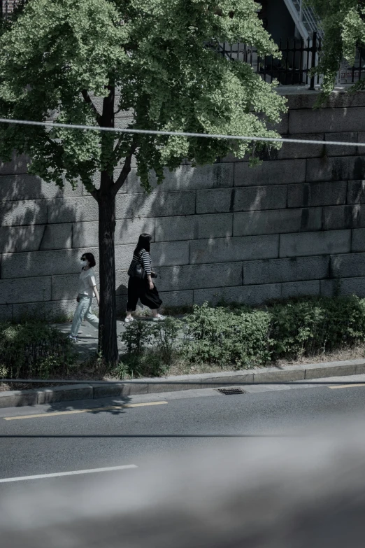 a car is seen driving past a stone wall