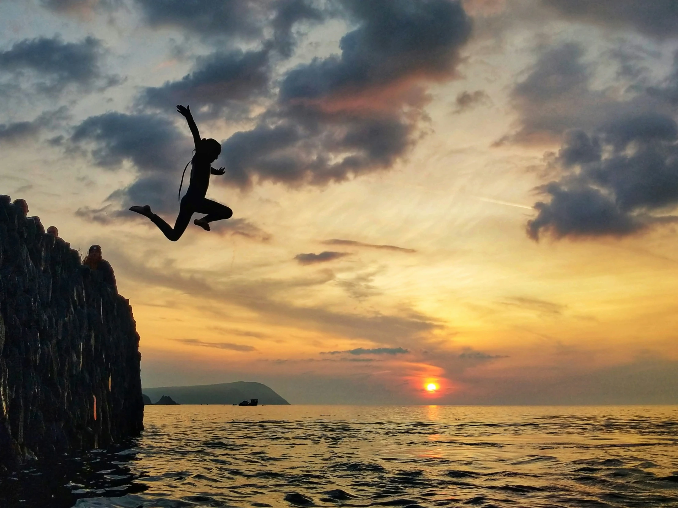 a young person is doing a jump off the pier