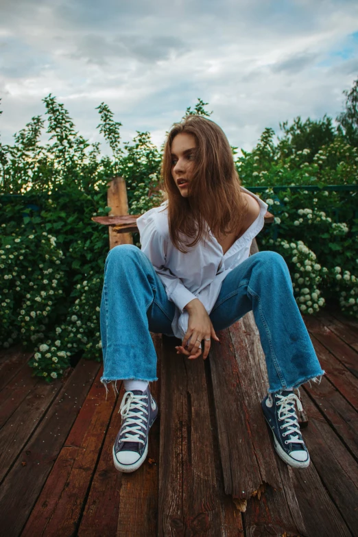 a girl sitting on a bench wearing blue and white tennis shoes