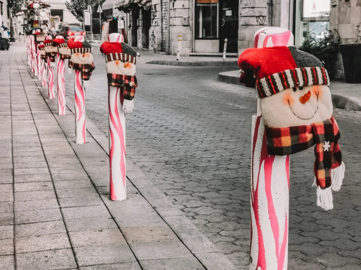 a street filled with lots of candy canes wearing snowmen