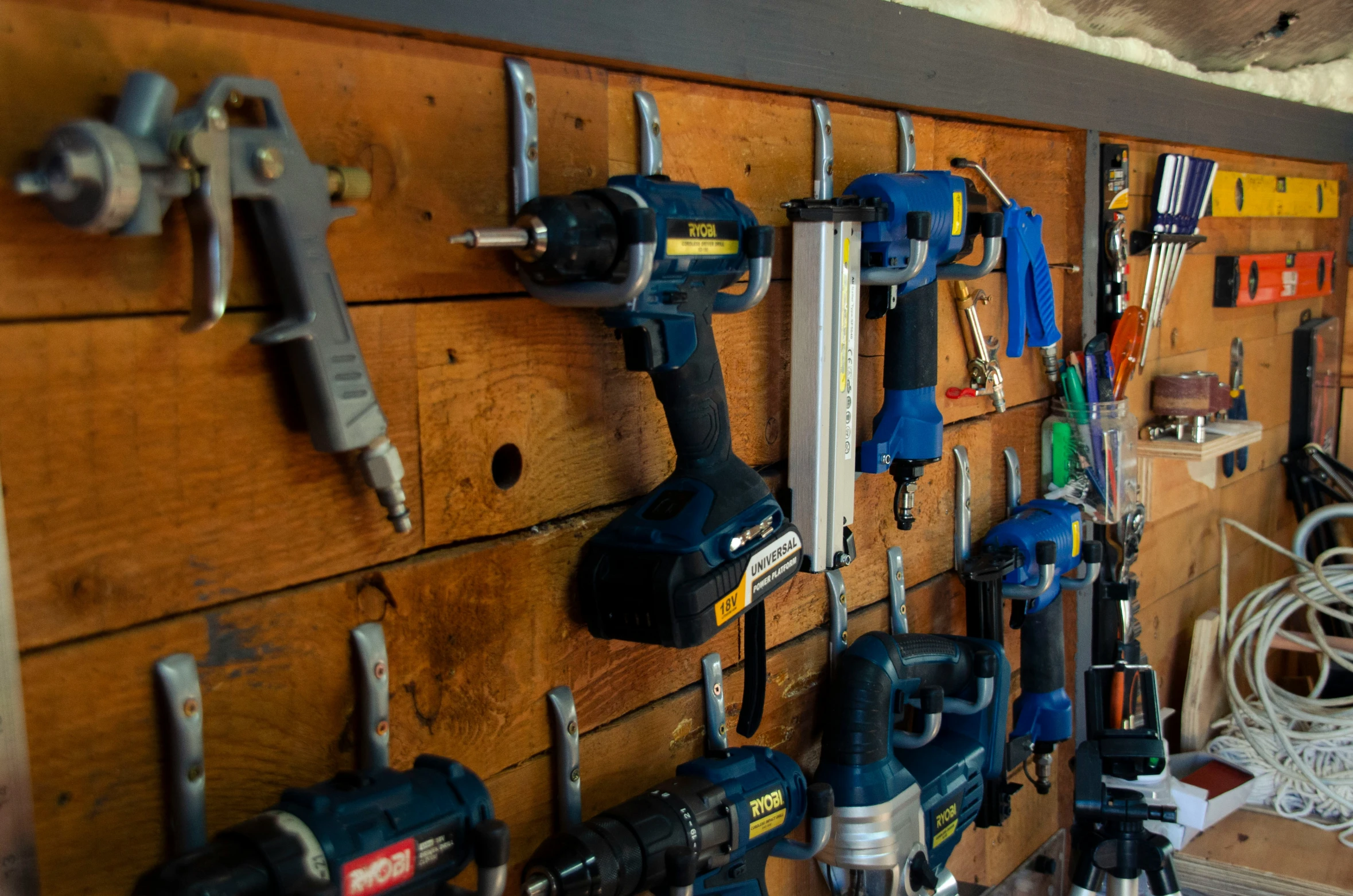 a bunch of work tools and supplies hanging on a wood surface