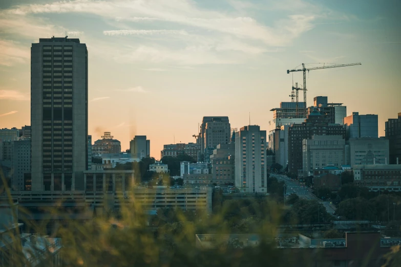 view of city buildings at dusk with the sun peaking in