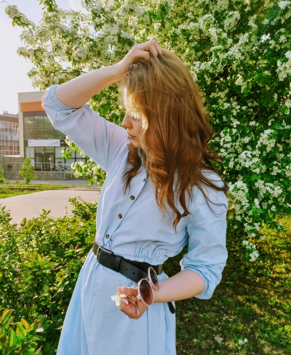 a woman is wearing a blue dress and black belt