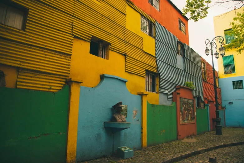 a colorful alleyway with a painted wall and bench