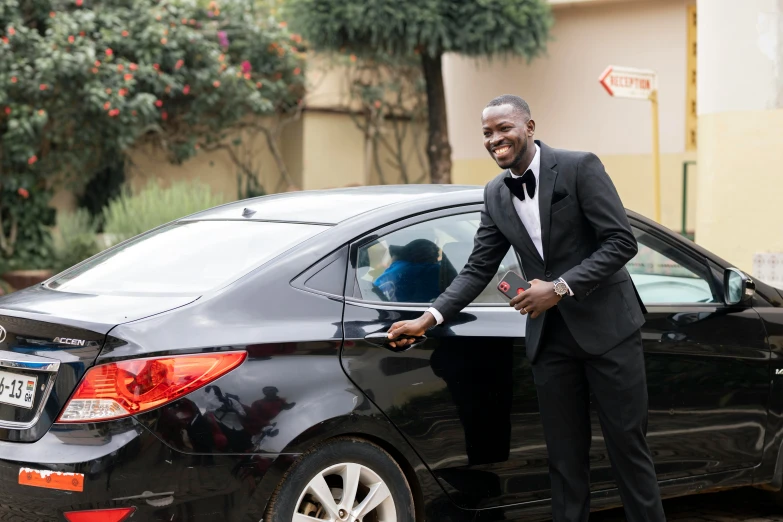 a man in a suit opening the door of a car