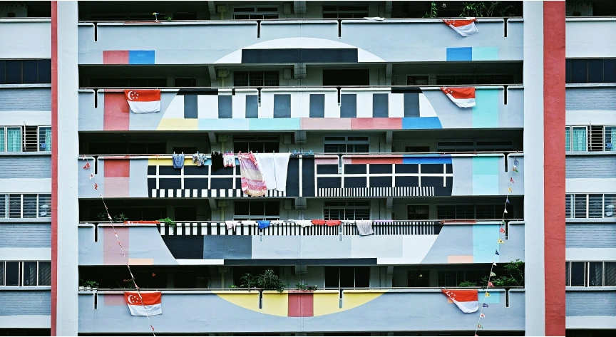 an apartment building with multiple balconies and flags on it