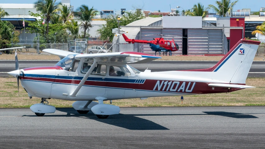 a small red and white plane sitting on the runway