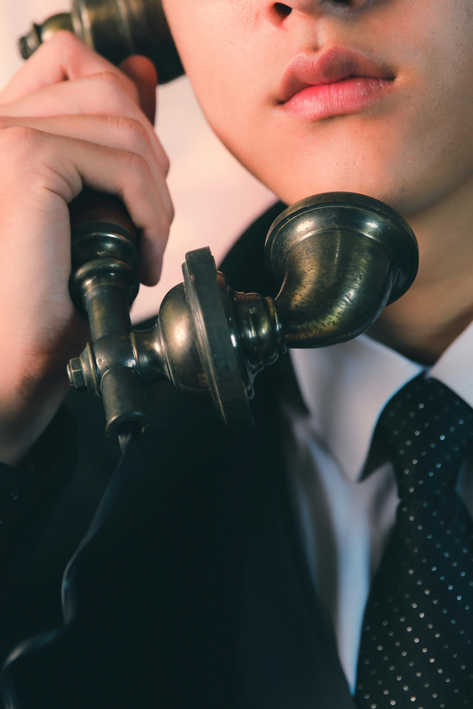 man in black tie holding ss telephone with two hands