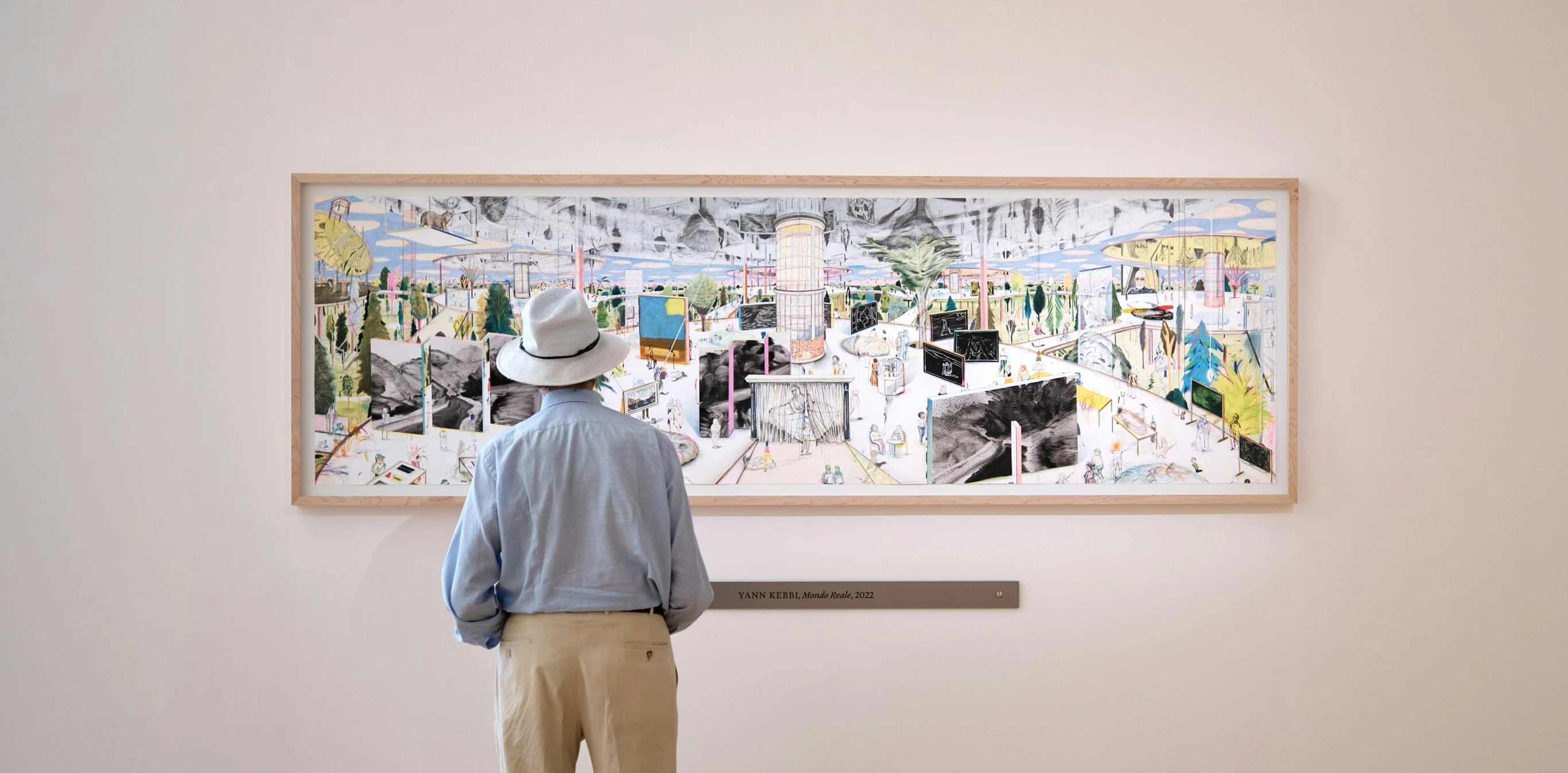 a man looks at a picture hanging on the wall