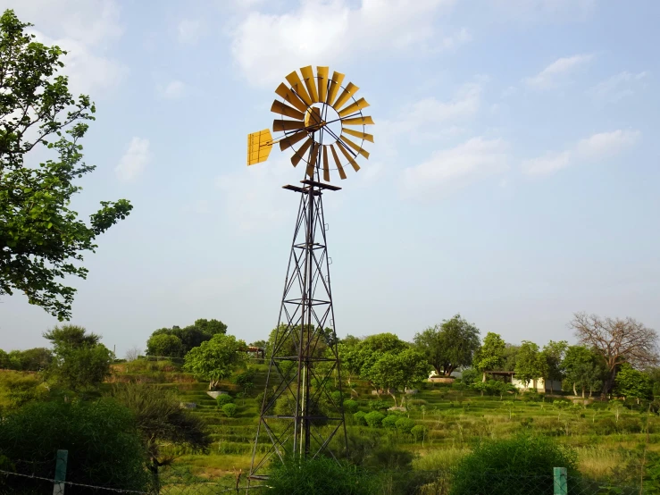 a windmill with two wind vaners on top and several trees