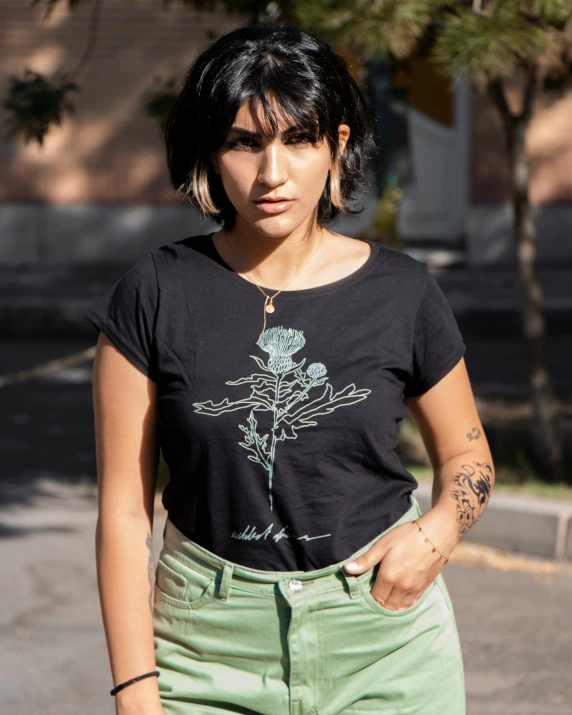 a girl with tattoo on her arm and black shirt on