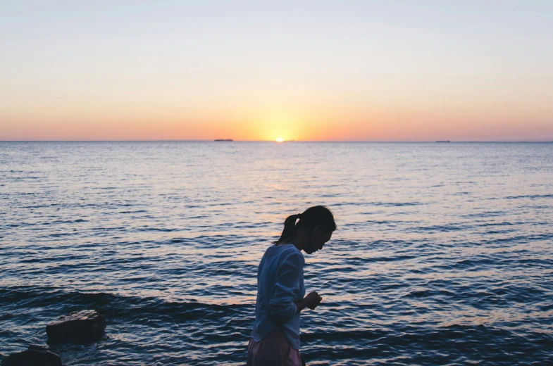 a  standing at the beach by the water