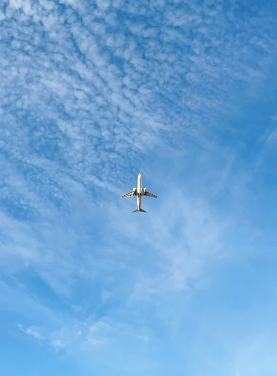 an airplane flying in the air on a cloudy day