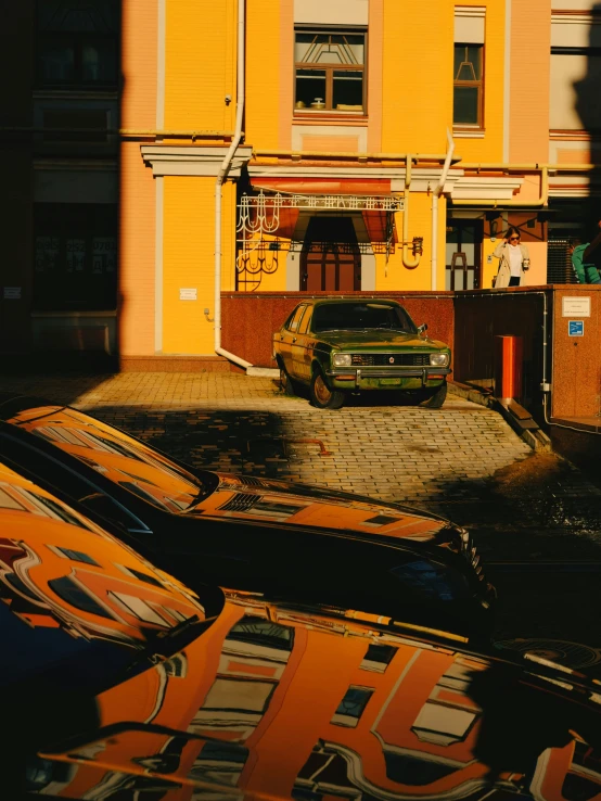 an orange building next to a parked car in the foreground