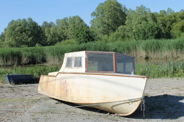 an old boat is sitting on a dry grass field