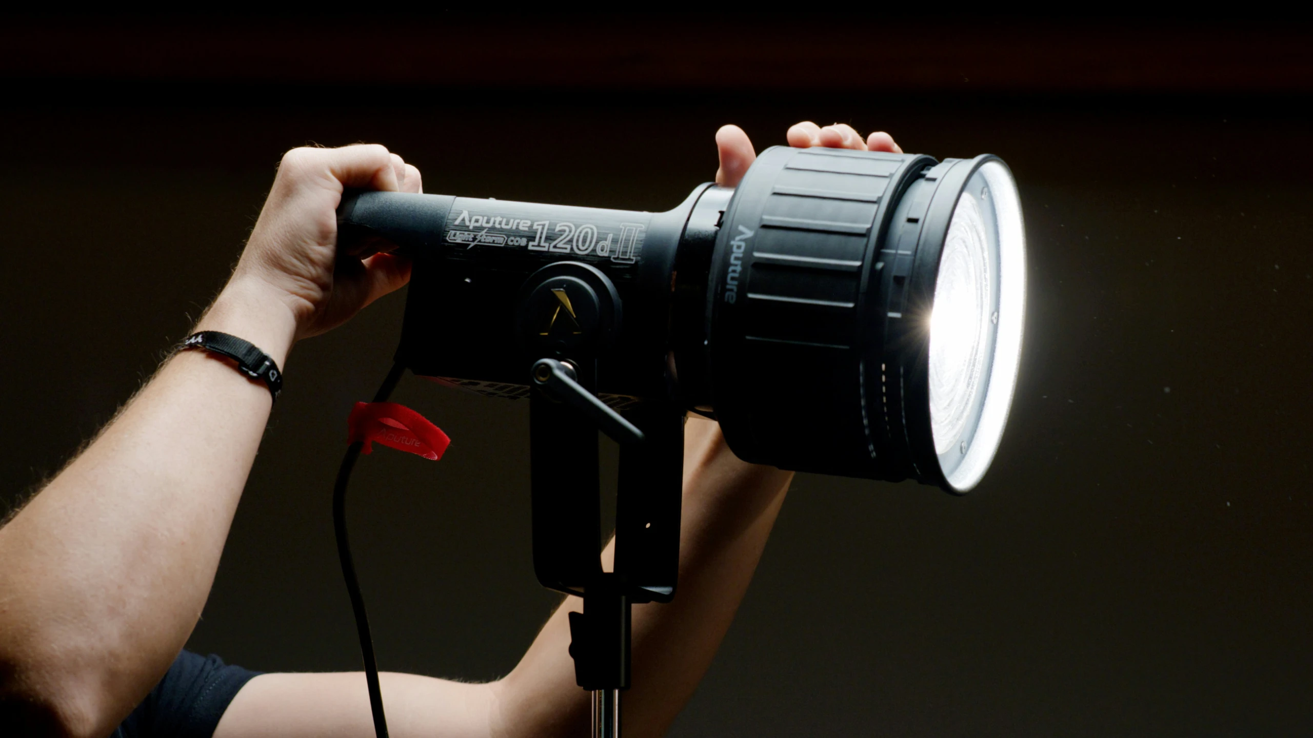 a person that is holding a light on a tripod