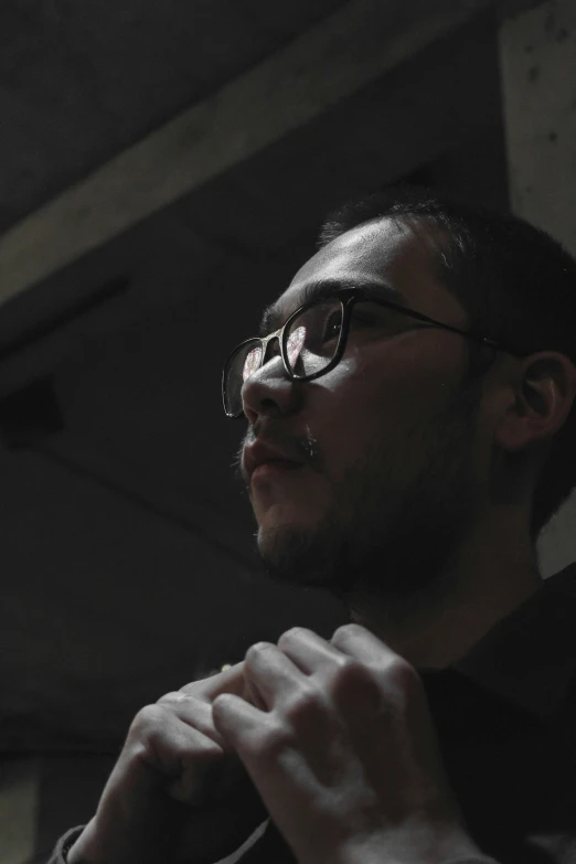 a man with glasses adjusting his tie