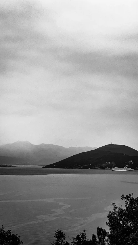 a po of a lake and a lighthouse with mountains in the distance