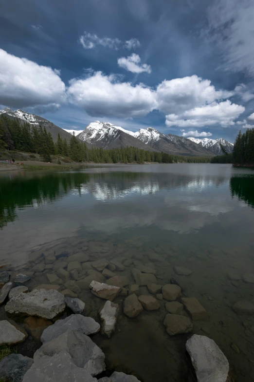 there are many rocks in the water by some mountains