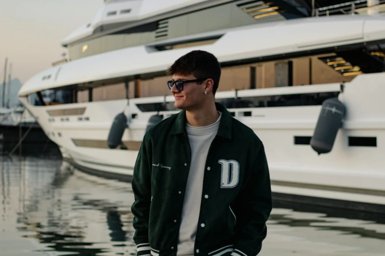 a man is standing on the dock with a white yacht in the background