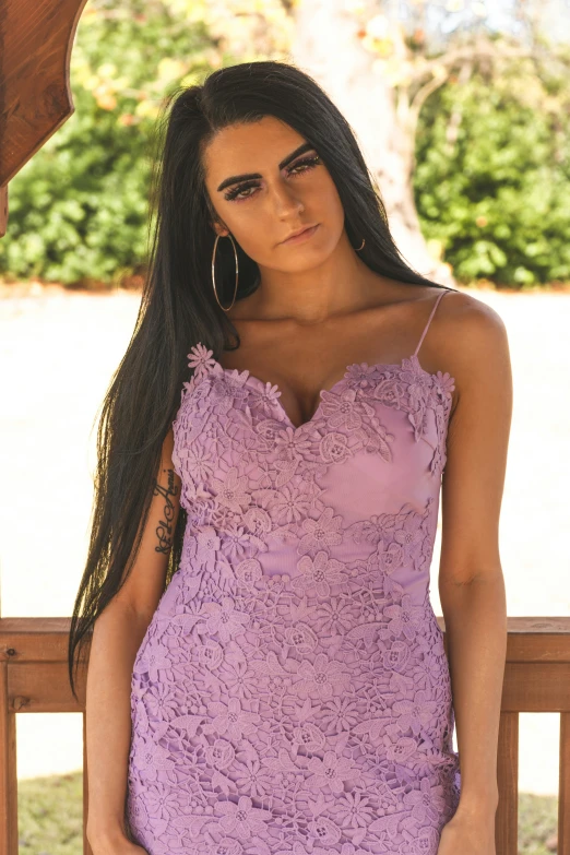 a beautiful woman posing in a purple dress