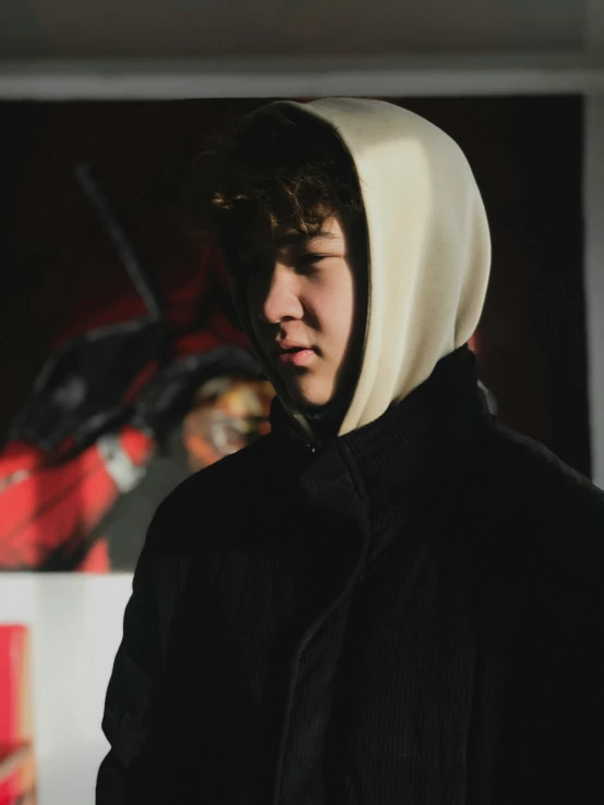 a young man wearing black hoodie standing in a room
