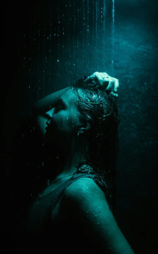 a woman holding her head under water with light streaming down