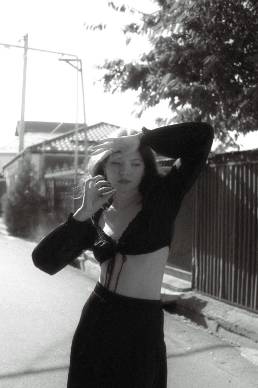 a woman is standing on the street talking on her phone